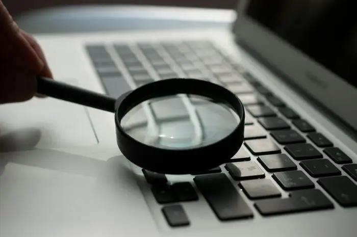 magnifying glass near laptop keyboard